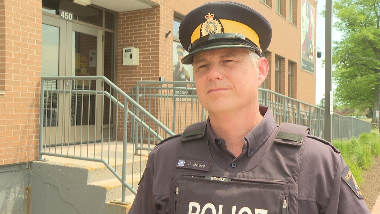 default-3556 An officer wearing a Royal Canadian Mounted Police (RCMP) uniform stands outside a brick police detachment building.