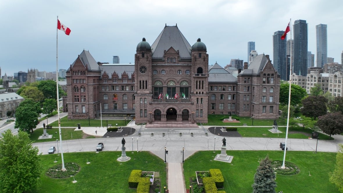A drone image of a big legislative building with flags.